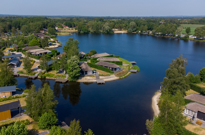 Luchtfoto van Recreatiepark De Tolplas aan een grote recreatieplas